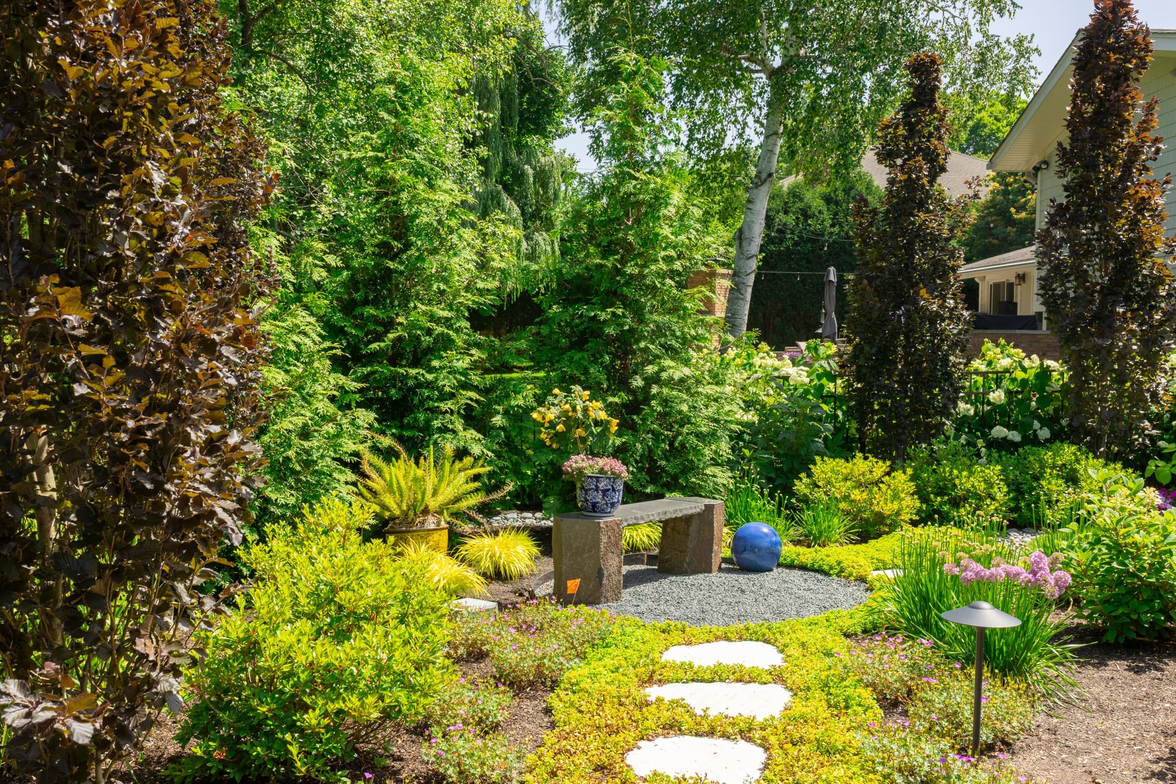 Garden bench nestled among stepping stones and perennials